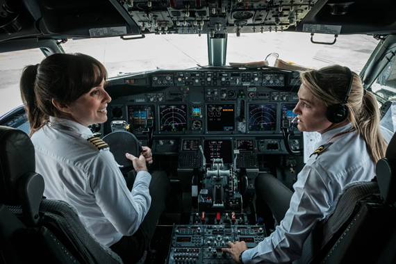 Two female pilots in cockpit smiling